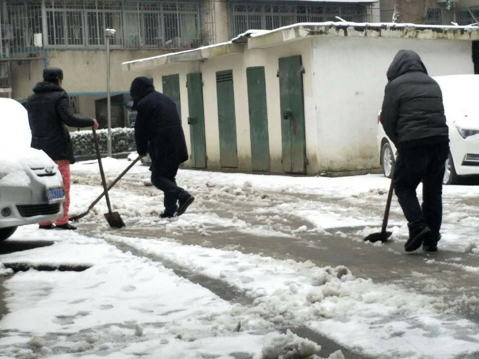 志愿者铲除积雪，方便居民出行