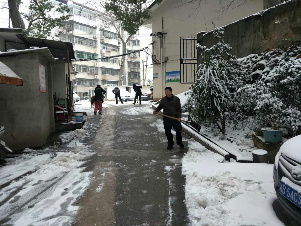 志愿者铲除积雪，方便居民出行