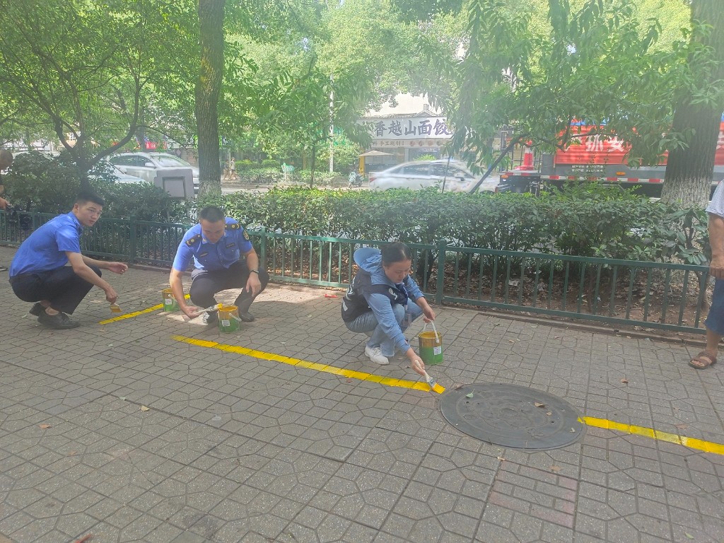 清水塘街道城管队员施(补)划车位,为非机动车“安家”、为城市提“颜值”